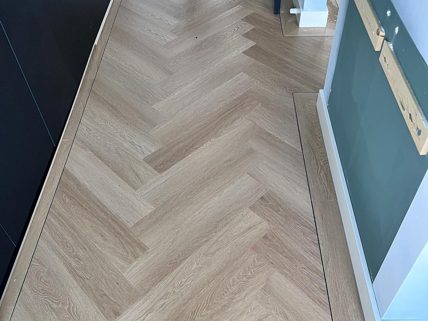 Detail visgraatvloer met band langs keuken