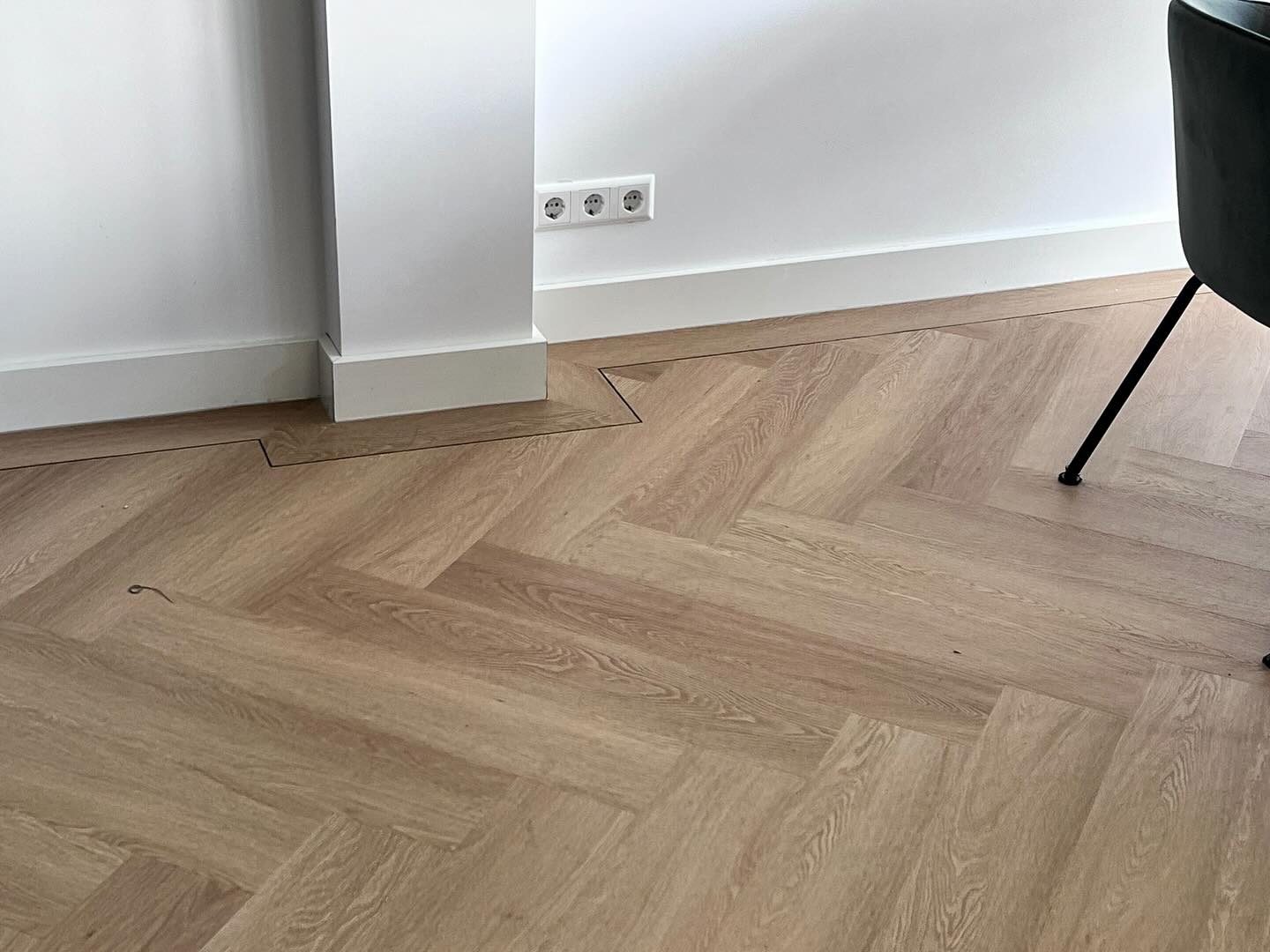 Visgraatvloer met band en bies rond kolom