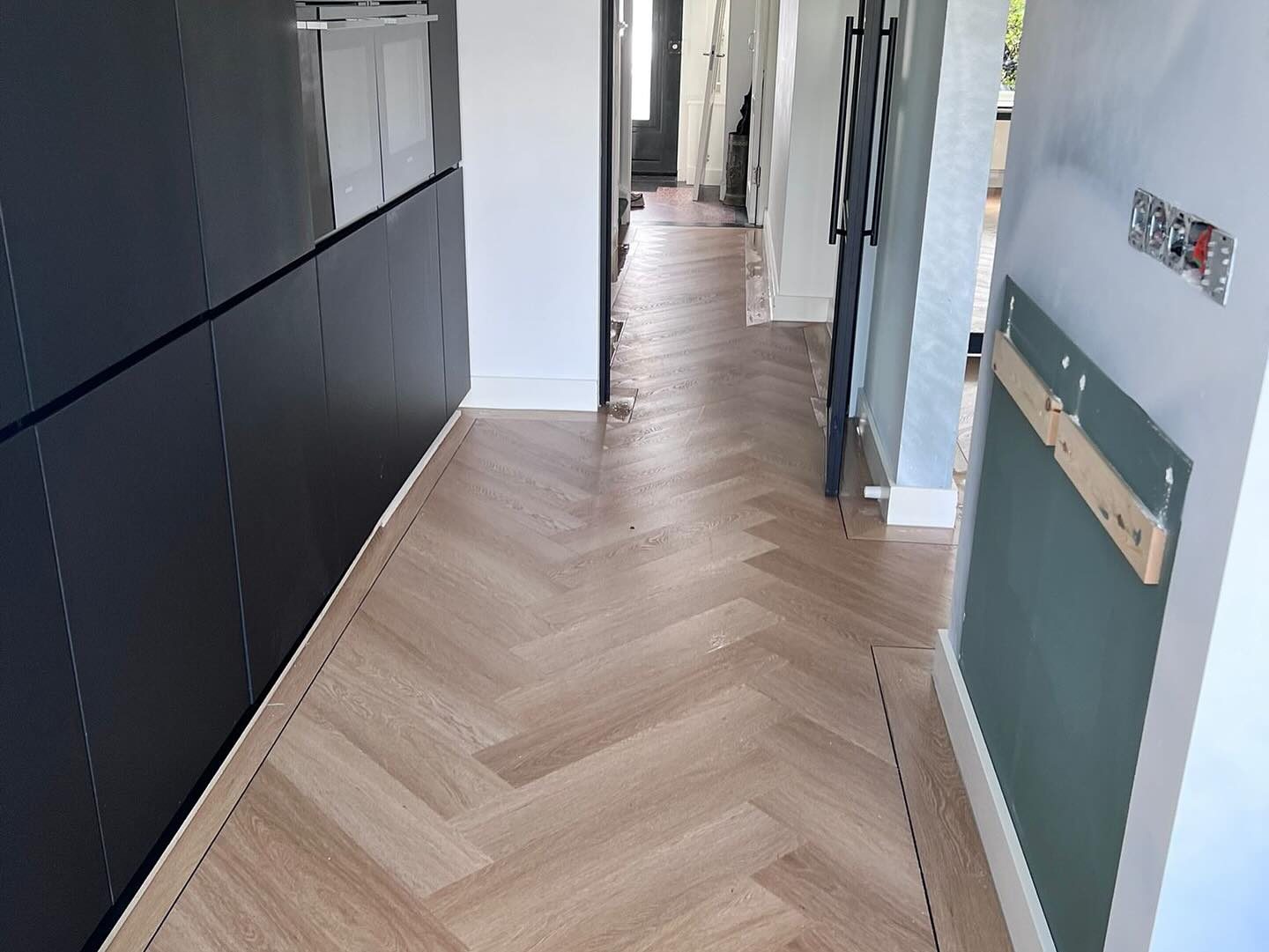 Visgraatvloer met band in moderne keuken
